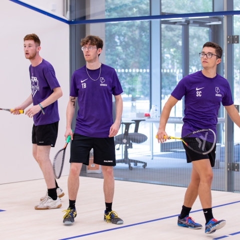 Photo of three students using the squash court - Ravelin Activities