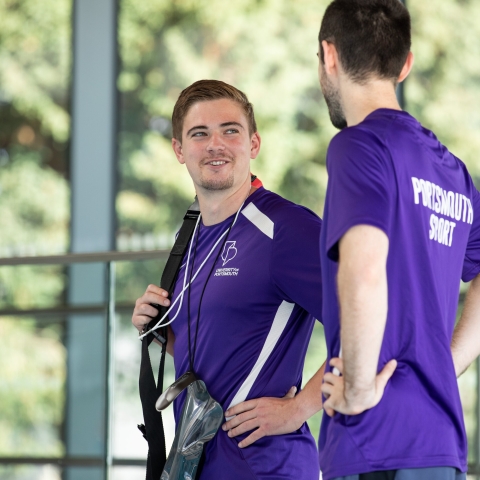 Two lifeguard staff smiling and talking at pool edge - Ravelin Activities
