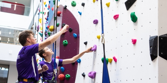 Instructor teaches child who to scale the bouldering wall at Ravelin Sport Centre.Ravelin Sports Event - Children