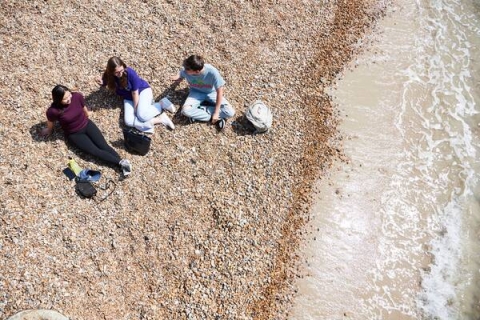 students sat talking on the beach