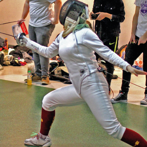 Student fencing with safety equipment on