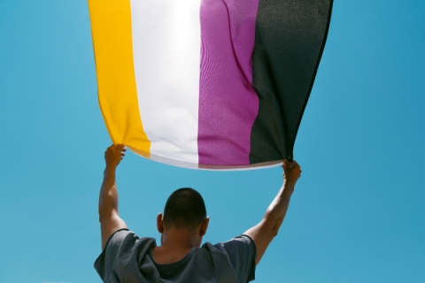 Person holding non binary flag