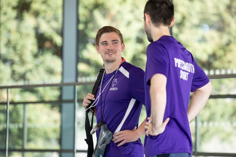 Two lifeguard staff smiling and talking at pool edge - Ravelin Activities