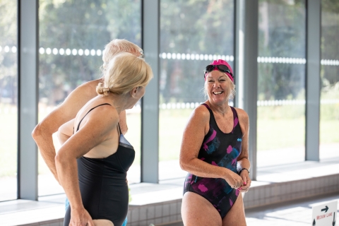 Three people smiling and talking at pool edge - Ravelin Activities