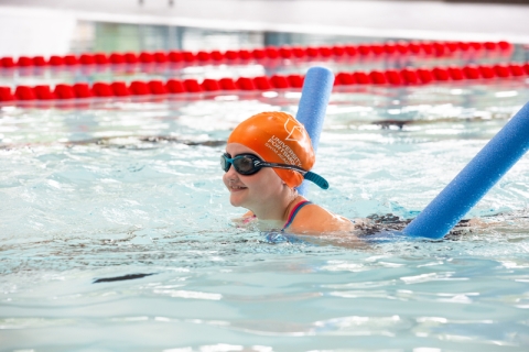 Child in orange cap learning to swim using floats in Ravelin Sport Centre.
Ravelin Sports Event - Children