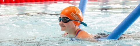 Child in orange cap learning to swim using floats in Ravelin Sport Centre.Ravelin Sports Event - Children