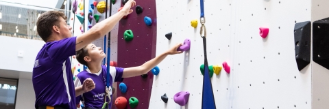Instructor teaches child who to scale the bouldering wall at Ravelin Sport Centre.Ravelin Sports Event - Children