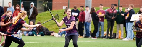 Team UOP Lacrosse player carrying the ball in a stick