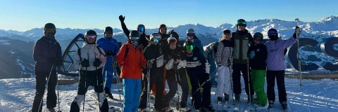 A group of students with skiing gear on a mountain