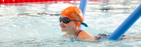 Child in orange cap learning to swim using floats in Ravelin Sport Centre.
Ravelin Sports Event - Children