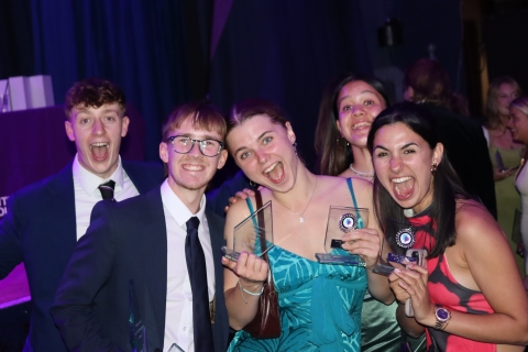 Students from Climbing club celebrating with glass trophies at Sports Awards