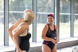 Three people smiling and talking at pool edge - Ravelin Activities