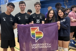 Team UOP students posing with a UOP pride flag
