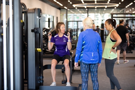 Women receiving induction on how to use fitness suite machines - Ravelin Activities